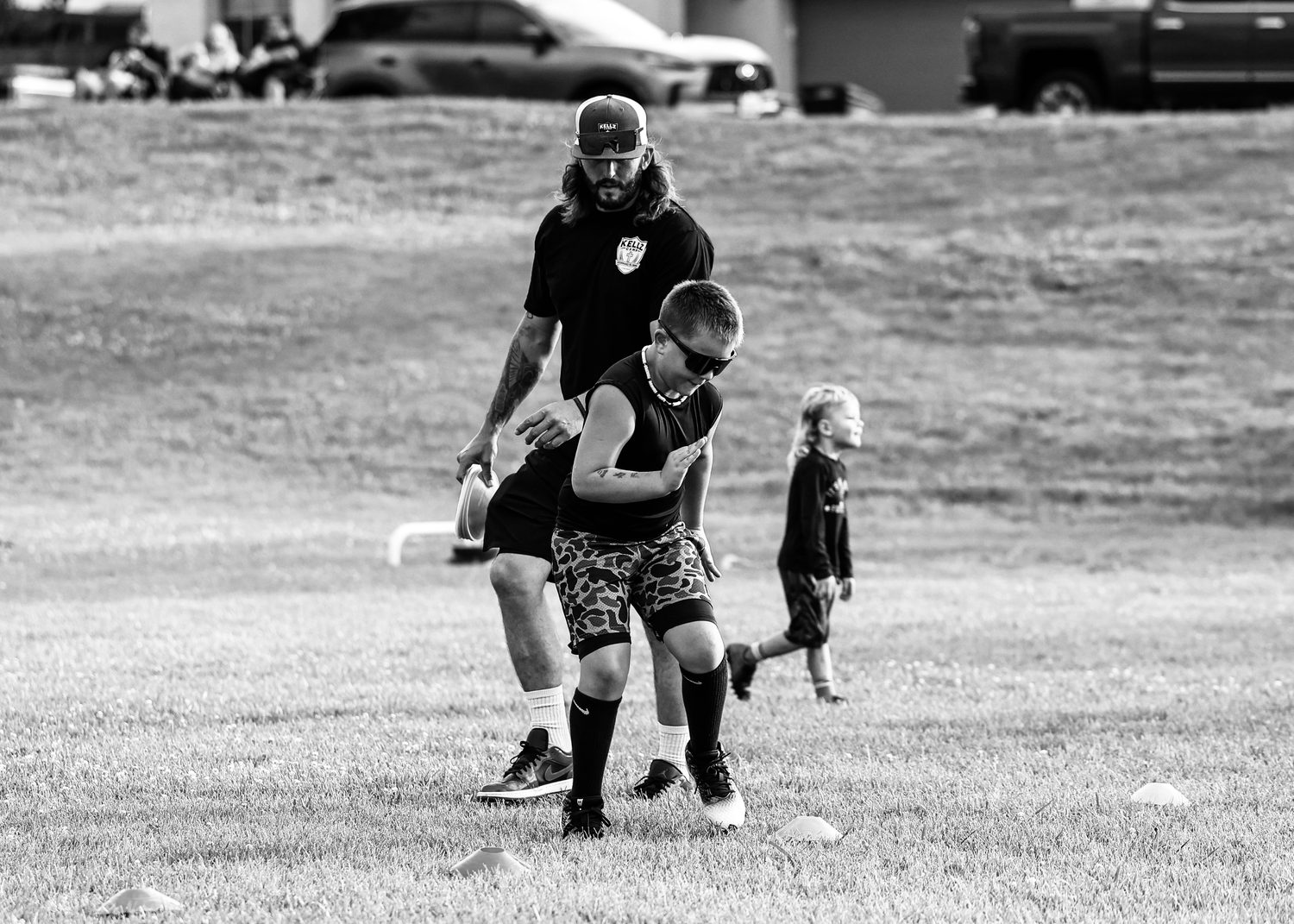 Coach Keller working hands-on with an athlete through a cone drill